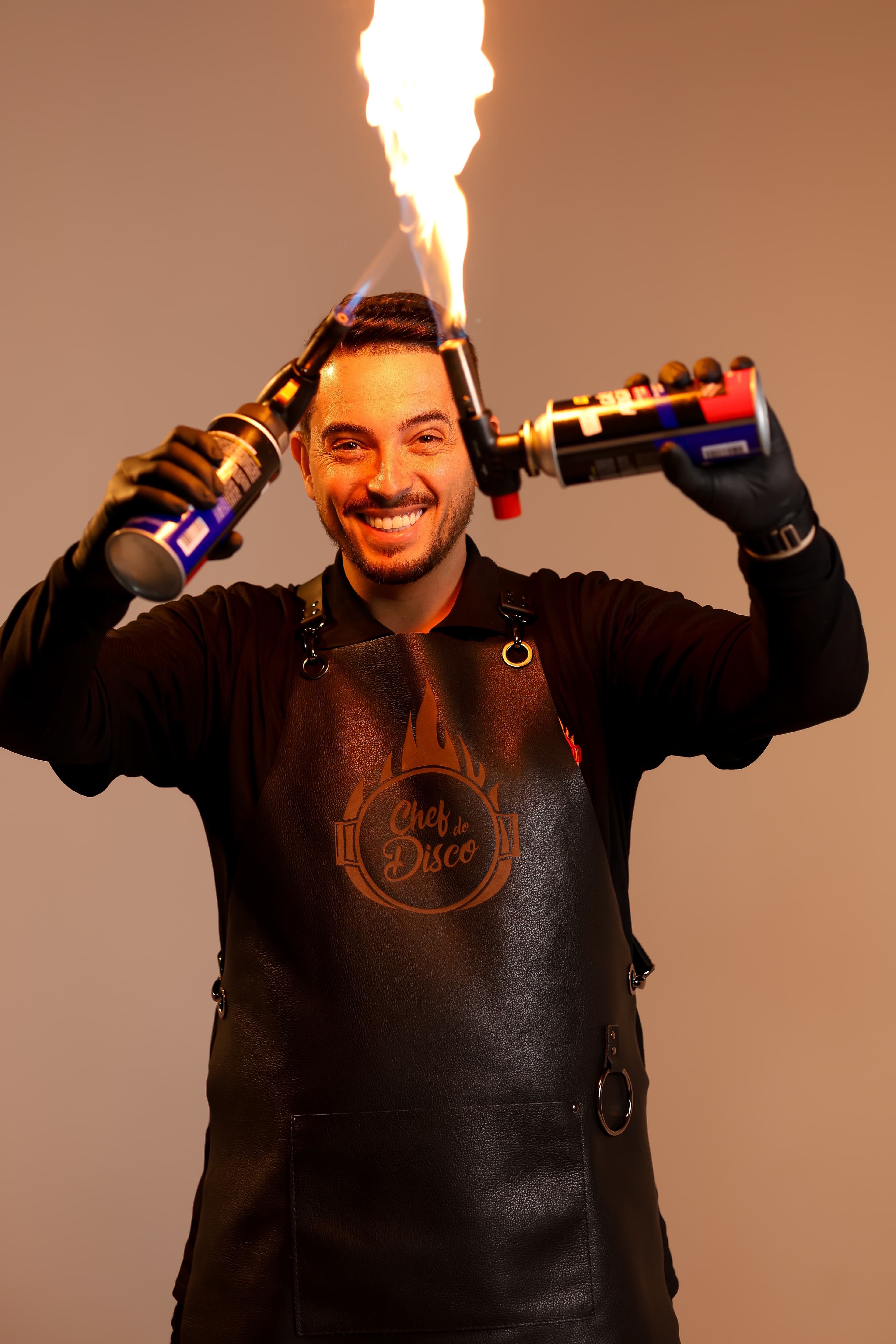 Vinicius Barreto em ação com fogo, vestindo o avental Chef do Disco